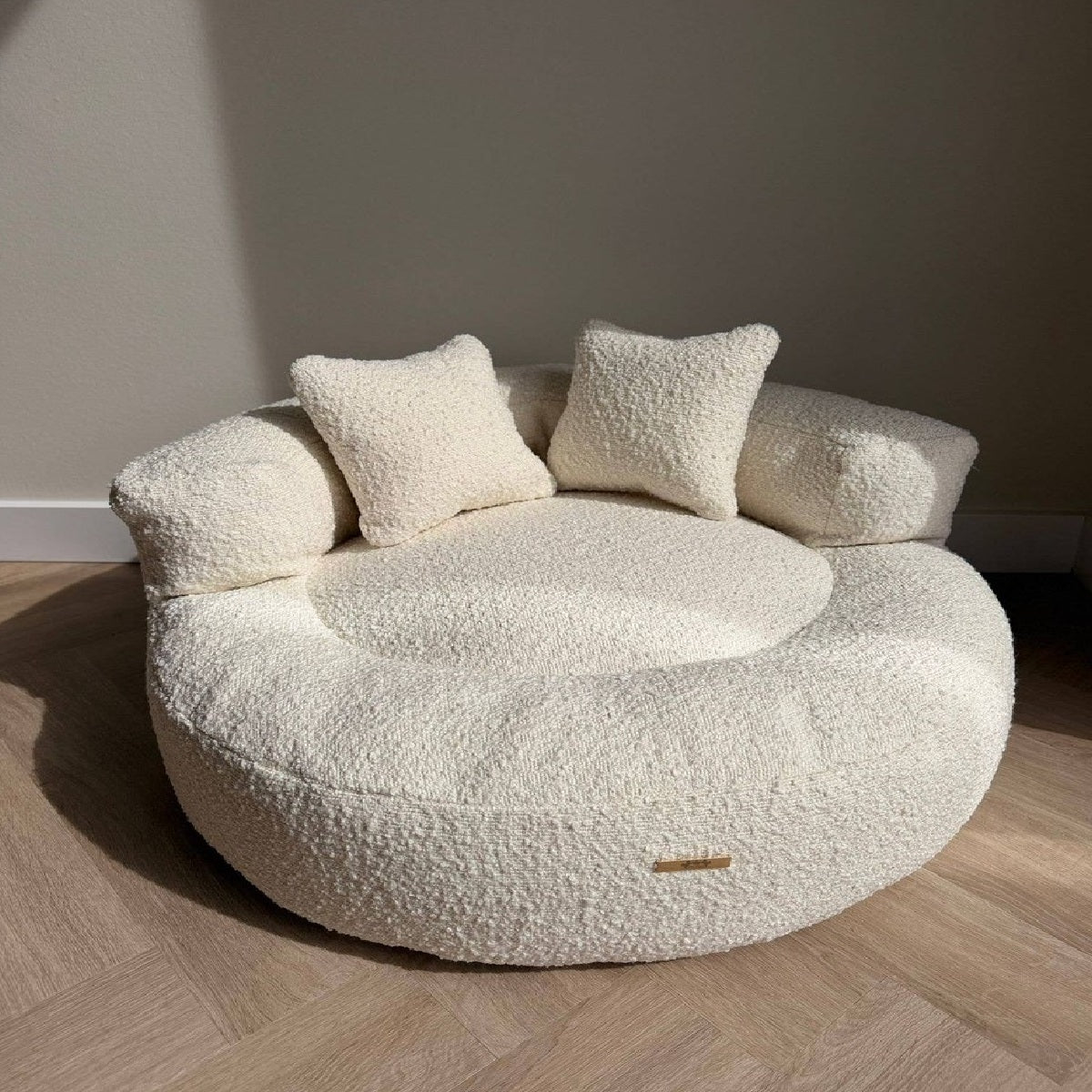 Canapea rotunda din boucle crem pentru caini, cu perne decorative
